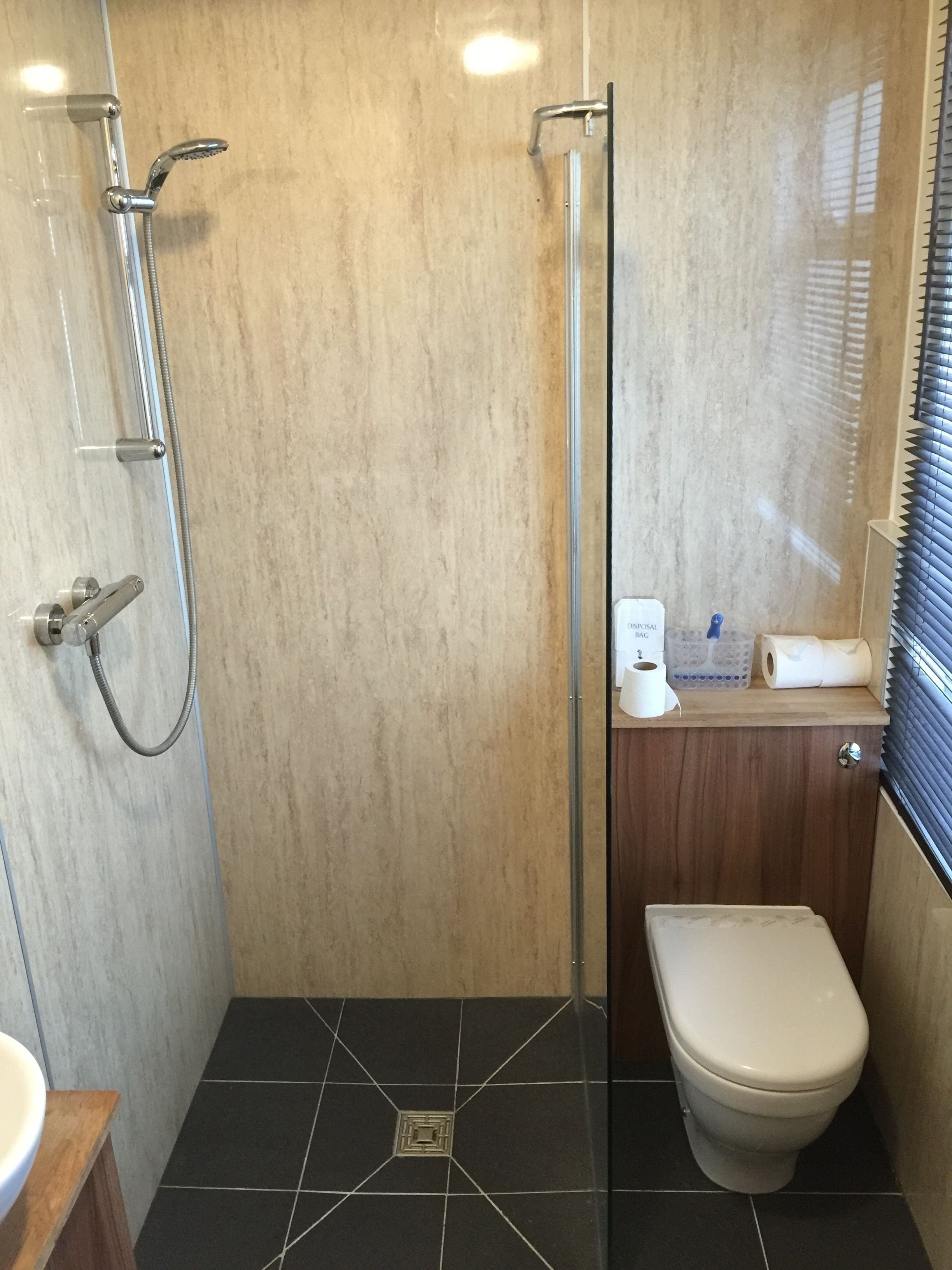 A bathroom with a shower, toilet, and sink.