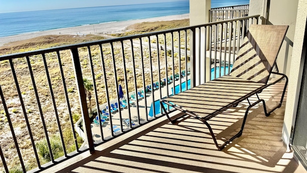 A balcony with a view of a beach and a pool. - Newly Renovated kitchen in this 2BR Beachfront Condo on the 6th Floor! (Orange Beach)