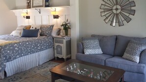 A bedroom with a bed, bedside tables, a nightstand, a lamp, a wall clock, and a decorative wall piece. - Last Wk of Aug Open!! Enjoy the creek, close to Pigeon Forge (Sevierville)