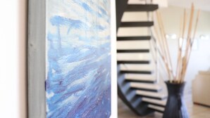 A staircase with a modern design, leading to a room with a blue abstract painting on the wall. - Crescent 1 Grace Bay Beach (Providenciales)