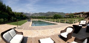 A pool area with wicker furniture and a view of mountains. - Olimagio (Pietrasanta)