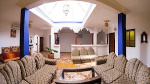 Ein geräumiges Wohnzimmer mit gestreiften Sofas, einem zentralen Couchtisch und einem Oberlicht.
