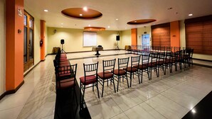 A conference room with a long table and chairs, a projector screen, and a speaker. - Hotel Casa Kolping Quito (Quito)