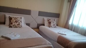 A hotel room with two beds, each with a pillow and a folded towel. - Hotel Casa Kolping Quito (Quito)