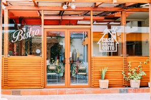 A restaurant with a wooden facade, glass doors, and a sign reading "Bistro". - Hotel Casa Kolping Quito (Quito)