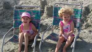 Two children sitting on beach chairs with colorful patterns, on a sandy beach. - Historic Charleston Charm-1 mi beach/6 m downtown/Comfort & Safety   (Mt Pleasant)
