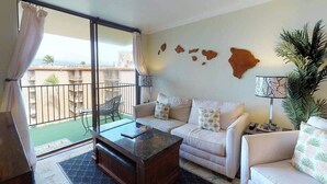 Un salon comprenant un canapé, une table basse et donnant sur un balcon avec une balustrade.