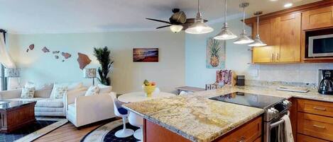 A modern kitchen with wooden cabinets, a granite countertop, and a built-in oven.