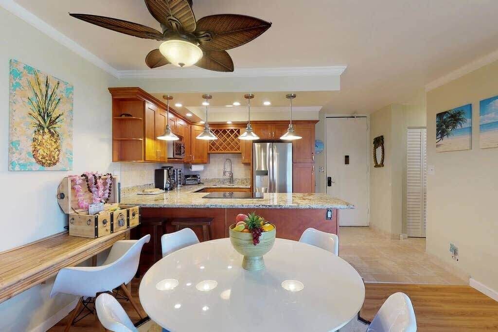 A modern kitchen with wooden cabinets, a central island, and pendant lighting.