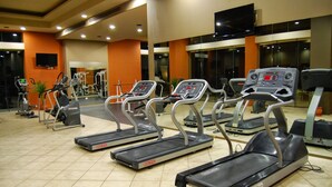 Ein Fitnessstudio mit Laufbändern, Crosstrainern und Gewichtsgeräten.