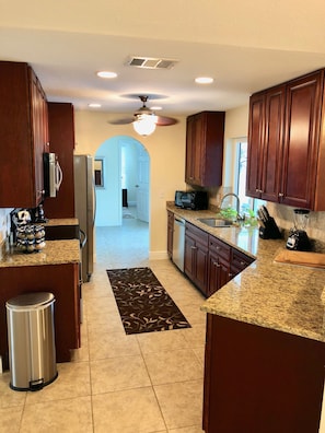 Enjoy cooking in this well-equipped kitchen with a refrigerator, microwave, and toaster, and access to natural light through a large window.