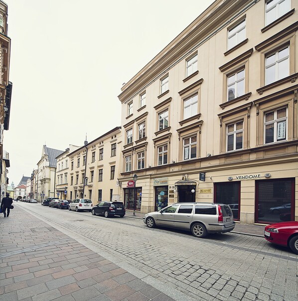 A street with parked cars and a building with a 'VENDOME' sign.
