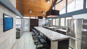 A modern kitchen with a long counter, stainless steel appliances, and a wooden ceiling. - Waterfront Home with Pontoon, Movie & Game Room-Perfect for Families & Getaways! (Park Rapids)