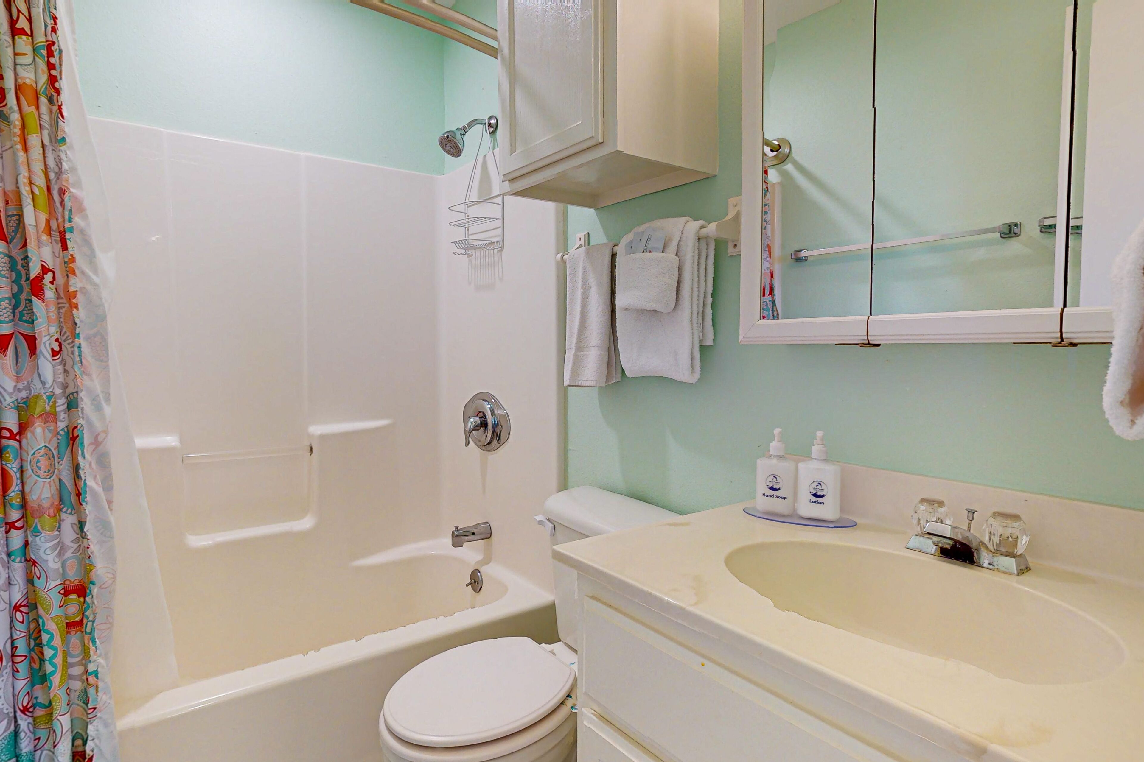 A bathroom with a bathtub, toilet, and sink.