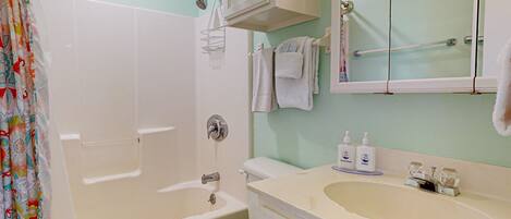 A bathroom with a bathtub, toilet, and sink.