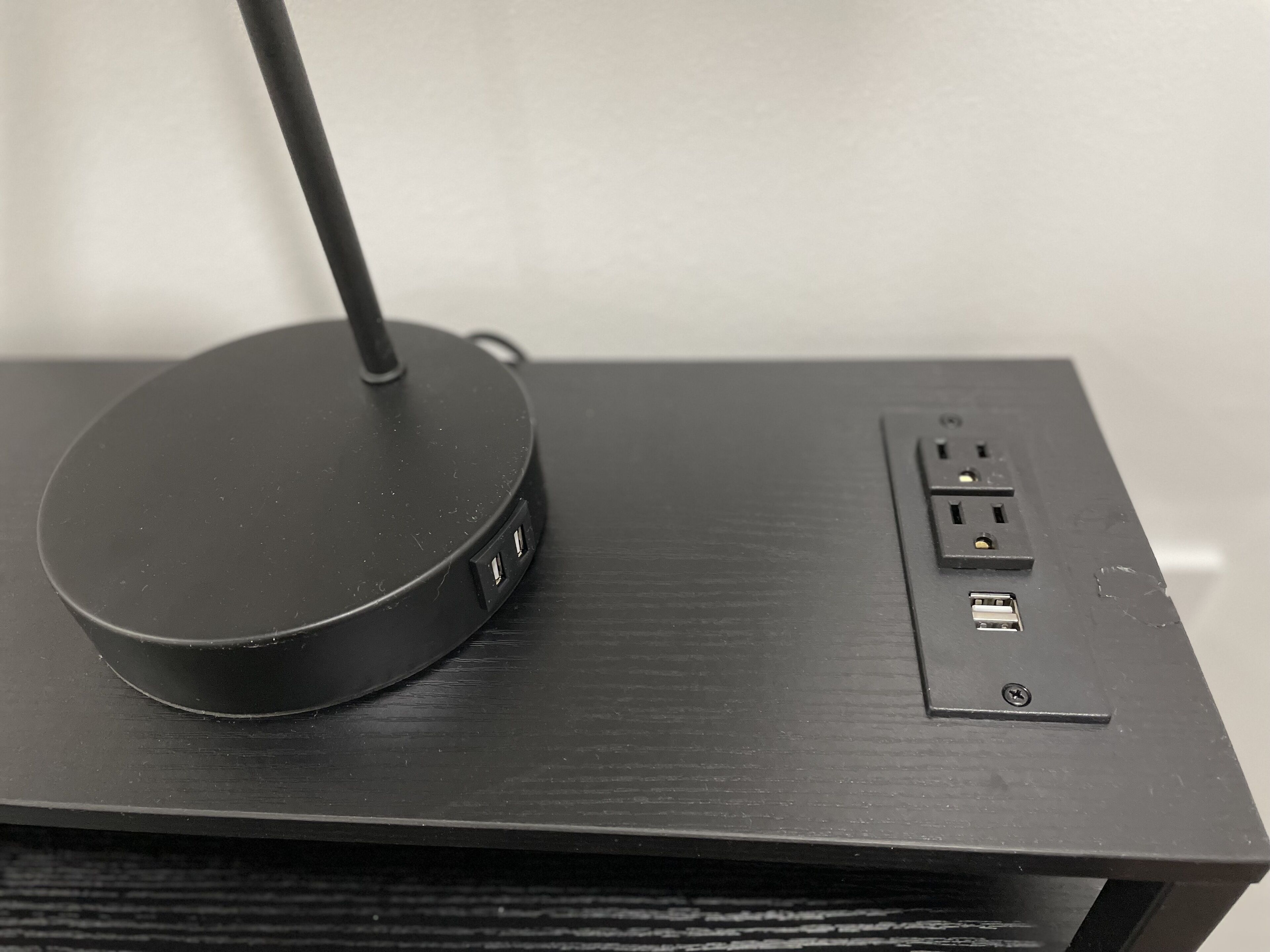 A black, circular, wireless charging pad on a wooden surface.