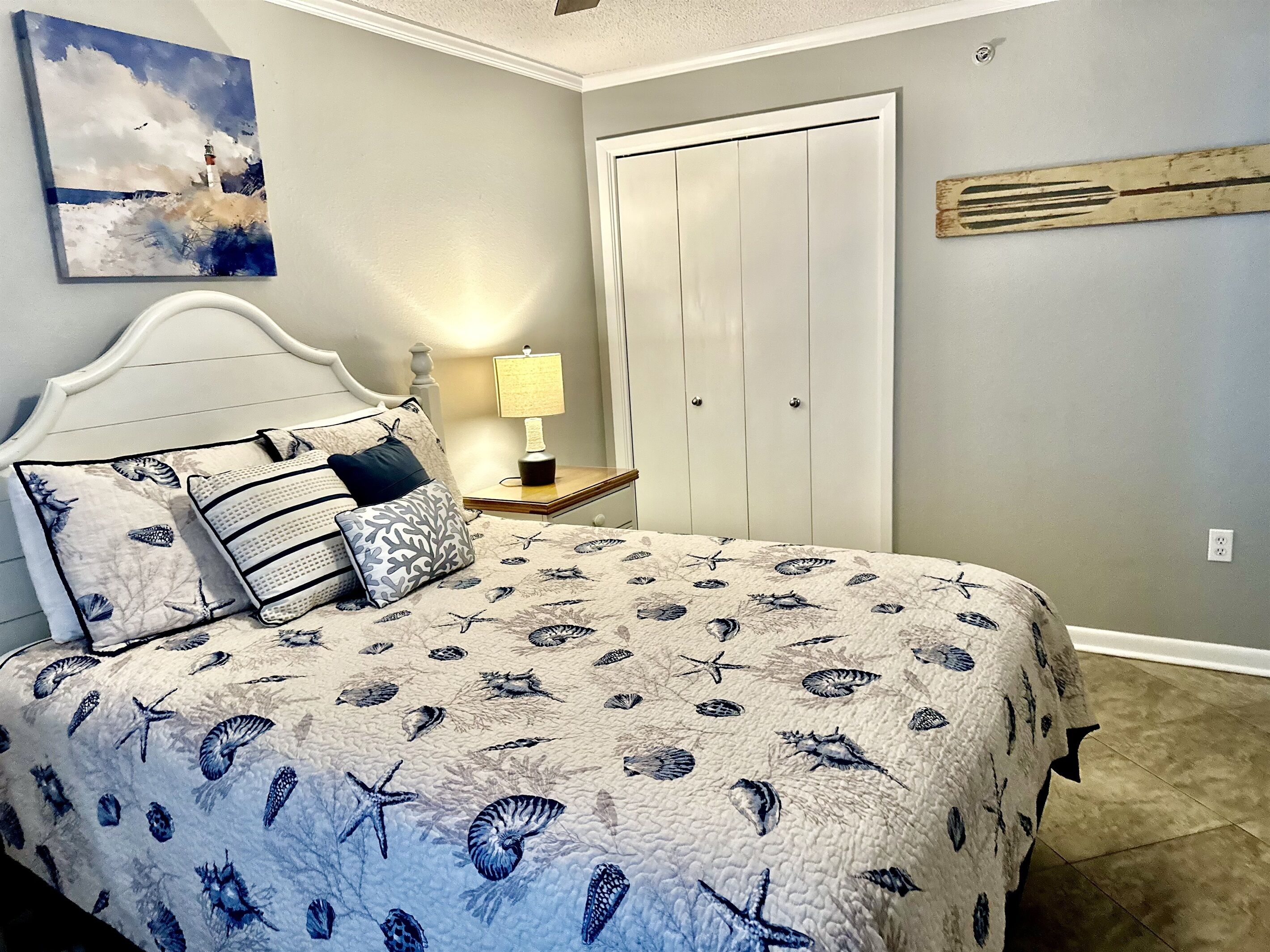 Une chambre à coucher avec un lit, une table de chevet, une lampe et une porte.