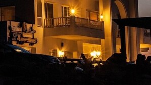 Un bâtiment à deux étages, doté d’un balcon, et un croissant de lune dans le ciel.