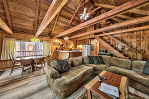 Un intérieur en bois comprenant un coin repas, un canapé et une cuisine.