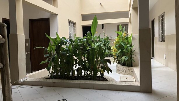 A courtyard with potted plants and a tiled floor. - Residence La Suite (St. Louis)