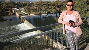 A person standing on a bridge with a river and trees in the background. - Garrett House | Hill Country retreat Kerrville - pool - hot tub - outdoor shower (Kerrville)