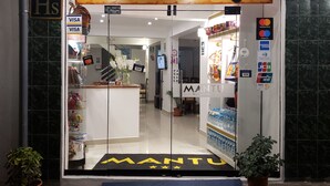 La entrada a MANTU BOUTIQUE con un cartel claro, opción de pago VISA y opción de pago DCC.