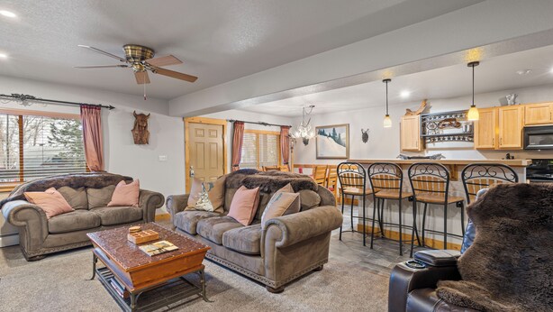 A spacious living room with two sofas, a coffee table, and a dining area with bar stools.