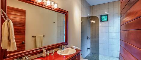 Un baño con dos lavamanos, un espejo grande y una zona de ducha.