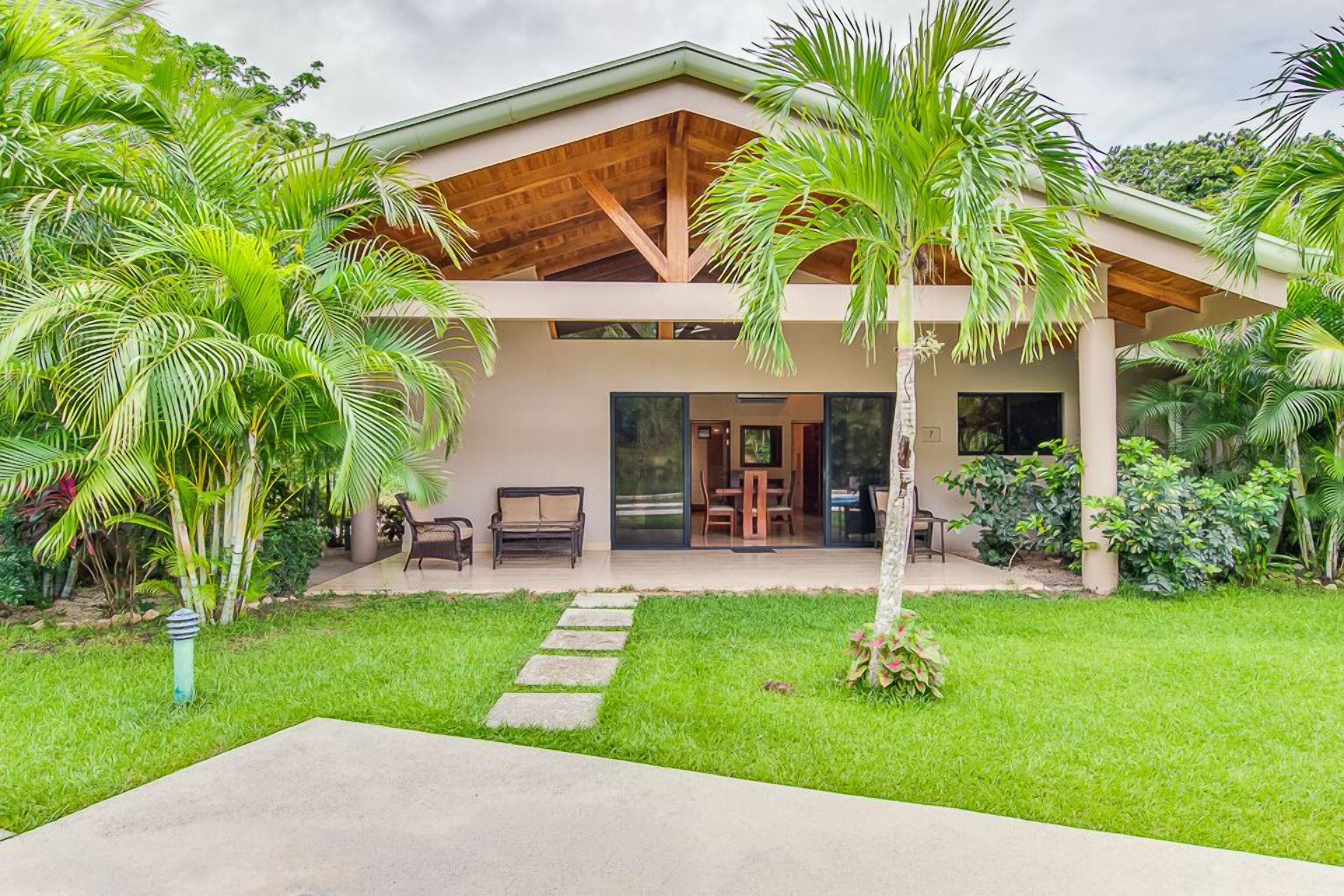 Une maison moderne avec un toit en bois, une véranda et une pelouse bien entretenue.