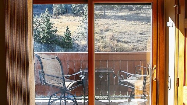 A room with a large arched window overlooking a deck area.