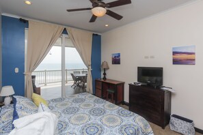 A bedroom with a bed, a desk, a television, and a view of the sea. - The Palms 703 (Jacó)