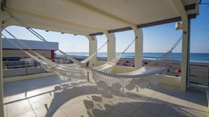 A hammock under a covered area with a view of the beach and ocean. - Casa Margarita Hotel And Paradise (Chiquimulilla)
