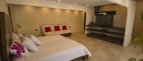 A modern bedroom with a large bed, a TV, and a built-in entertainment unit.