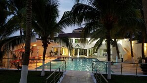 A swimming pool area with palm trees, a covered seating area, and a building with a staircase. - Casa Margarita Hotel And Paradise (Chiquimulilla)