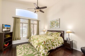A bedroom with a bed, a ceiling fan, a TV, and a window with curtains. - Beautiful home w/ private heated pool in quiet gated community. (Mesa)
