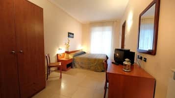 Ein Hotelzimmer mit Bett, Schreibtisch, Stuhl, Kleiderschrank, Fernseher und Spiegel.