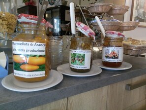 A kitchen counter with jars of marmellata di arance, kiwi, and albacocche. - Hotel Arma (Taggia)