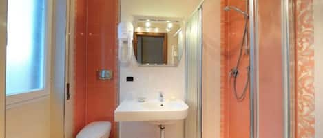 A bathroom with a toilet, sink, and shower.
