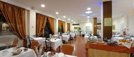 A spacious dining area with multiple tables, chairs, and a buffet setup.