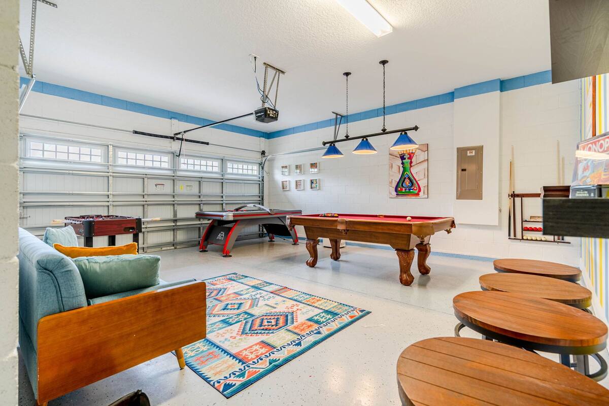 Sala recreativa con mesa de billar, mesa de futbolín y mesa de billares. Hay varias zonas de estar con mesas y sillas.