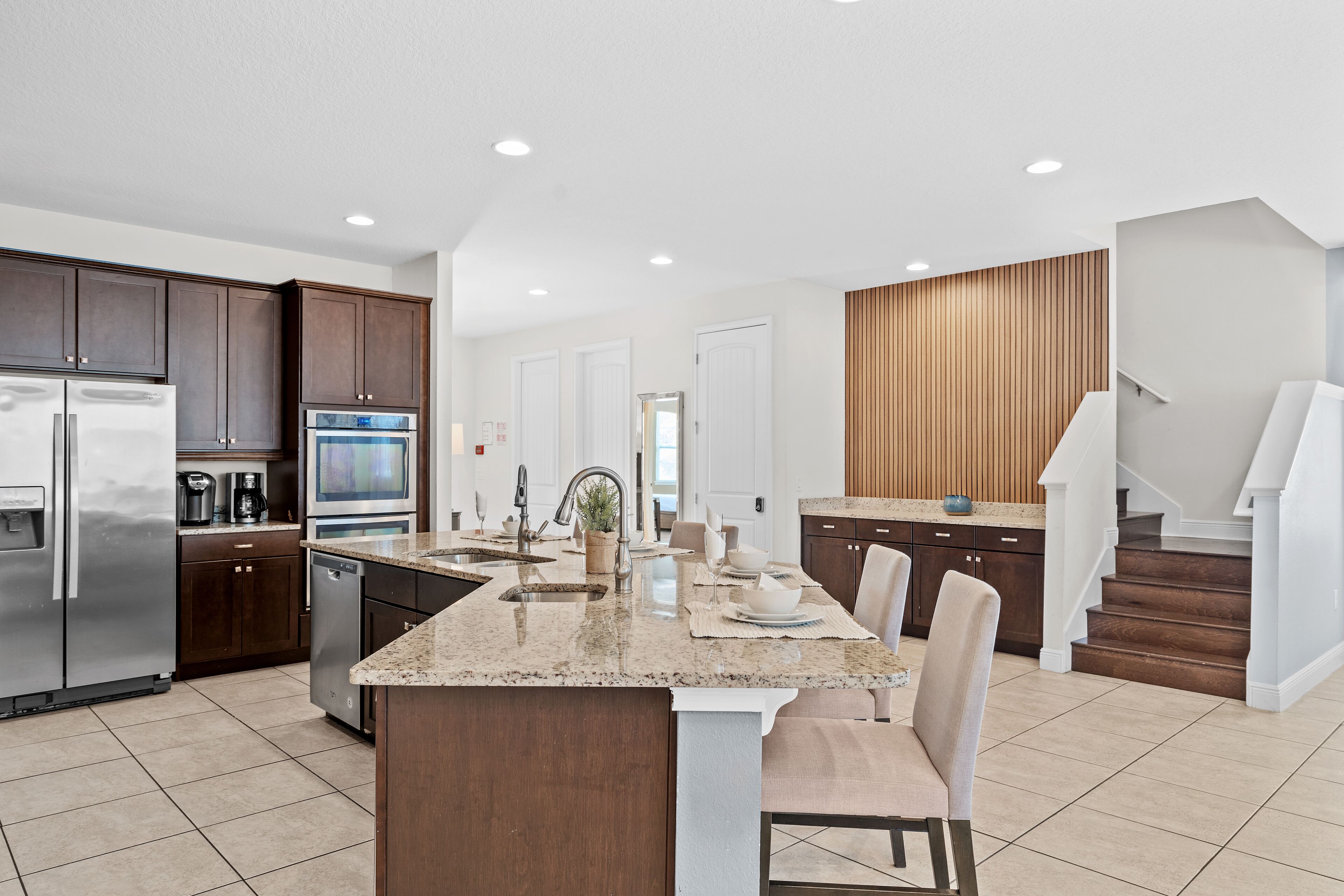 A modern kitchen with granite countertops, stainless steel appliances, and a central island.