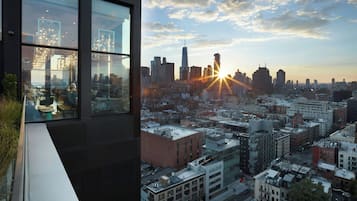 Een modern gebouw met grote ramen met uitzicht op een stadsbeeld bij zonsondergang.