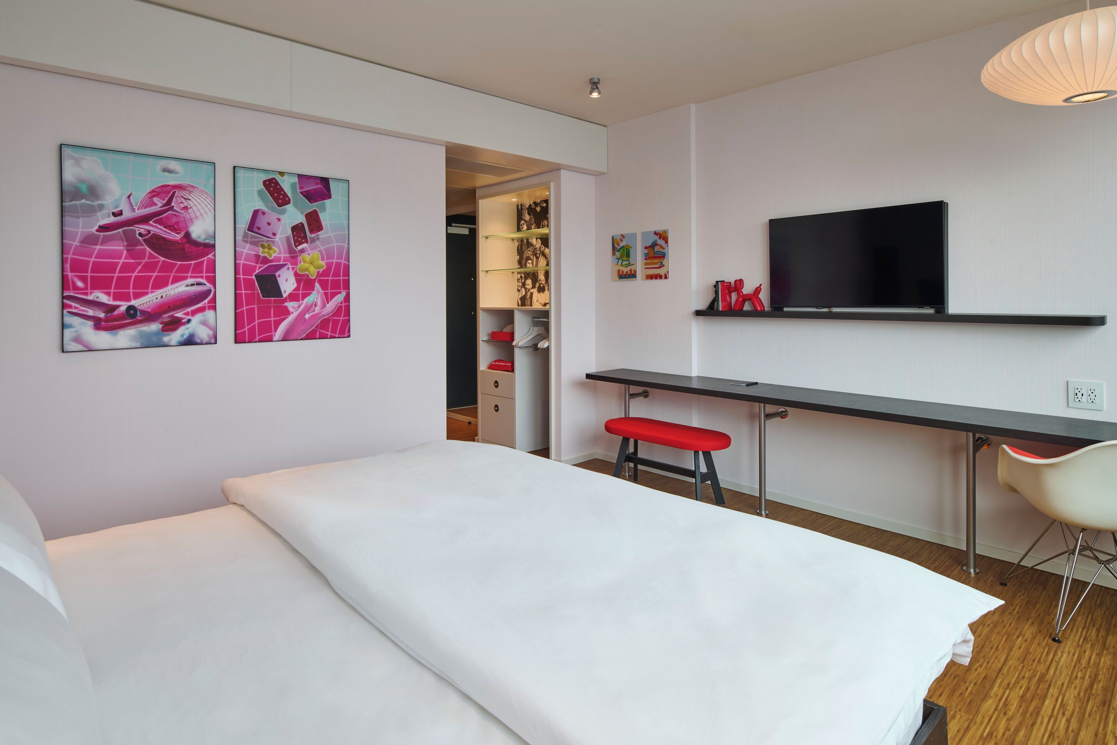 Una habitación de hotel moderna con una cama, un escritorio y un televisor.