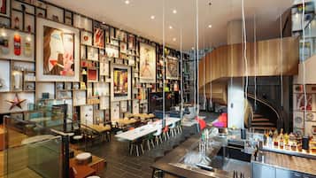 Un interior moderno con una zona de bar, asientos y una escalera.
