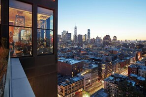 A high-rise building with large windows overlooking a cityscape at dusk. - citizenM New York Bowery (New York)