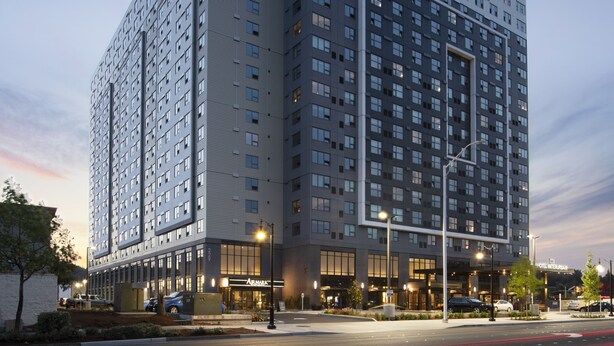 A modern hotel with a prominent corner entrance, multiple floors, and a well-lit facade. - Hotel Interurban Seattle Airport SeaTac (Tukwila)