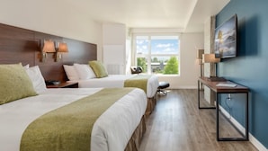 A hotel room with two beds, a desk, a chair, and a large window. - Hotel Interurban Seattle Airport SeaTac (Tukwila)