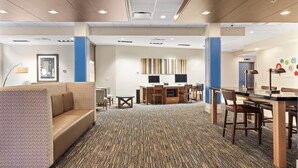 A hotel lobby with a seating area, a reception desk, and a computer station. - Holiday Inn Express & Suites Macon North by IHG (Macon)