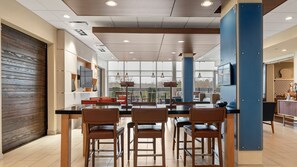 A modern kitchen with a central island, bar stools, and a large window offering a view of the outdoors. - Holiday Inn Express & Suites Macon North by IHG (Macon)