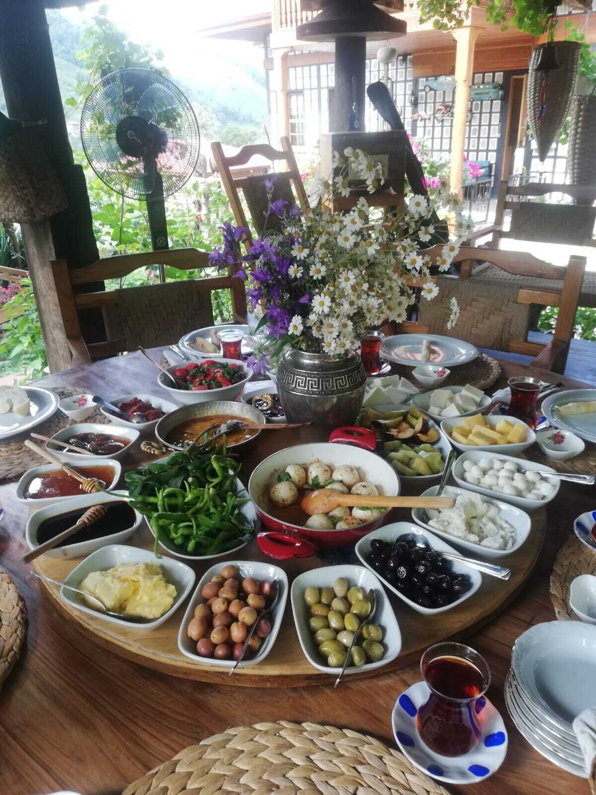 Una mesa dispuesta con diversos platos y un florero decorativo.